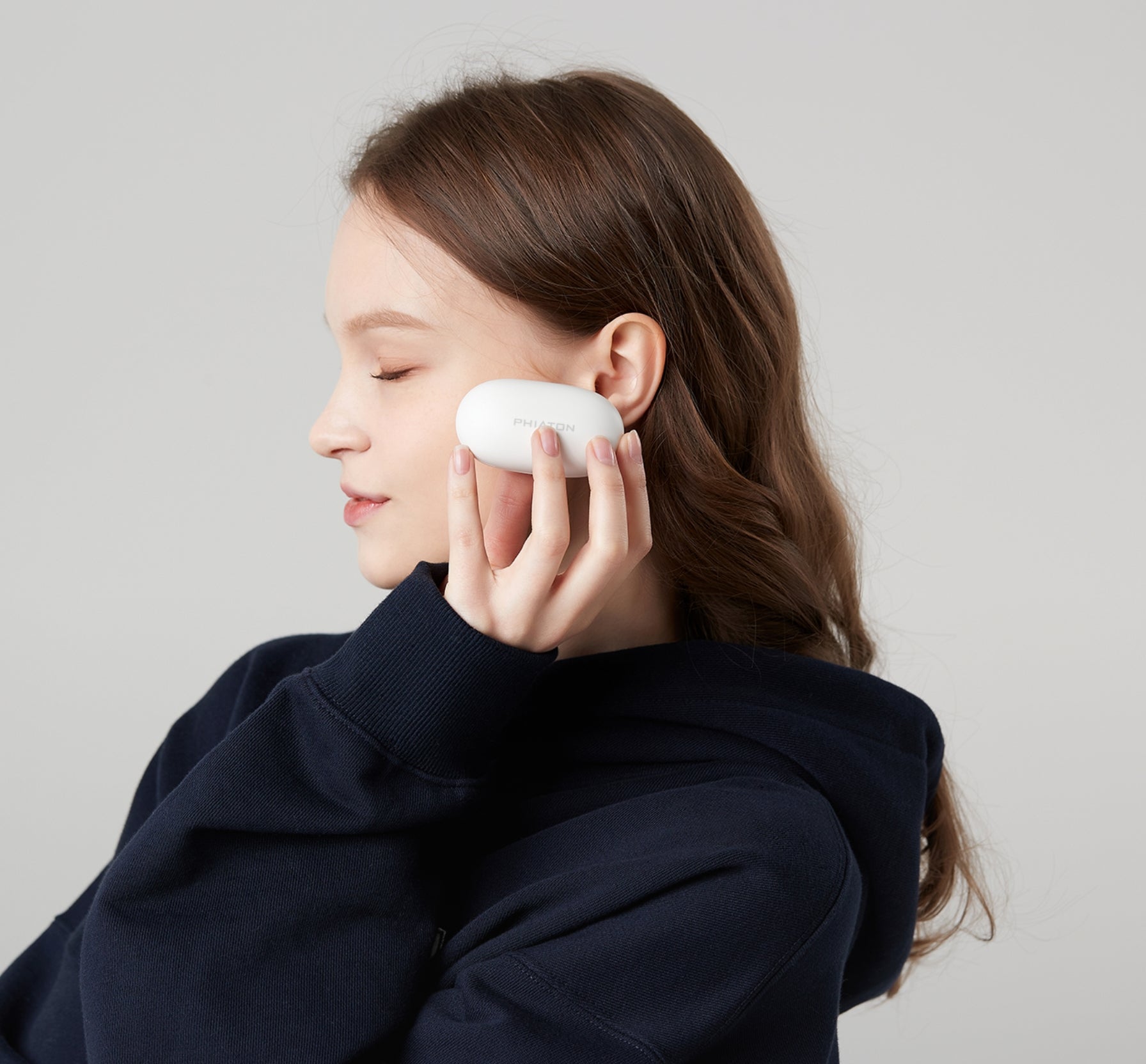 young woman holding earphone case up to ear